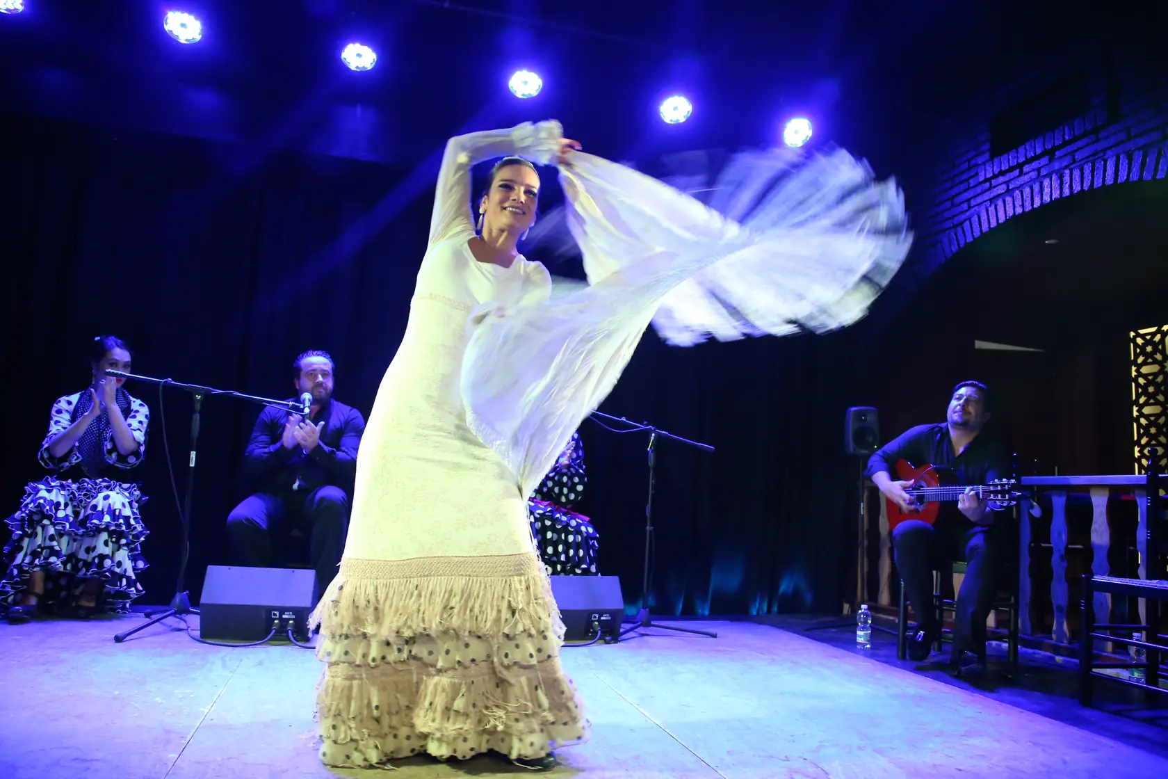 Tanečnice flamenca během vystoupení v intimním, teple osvětleném flamenkovém prostoru